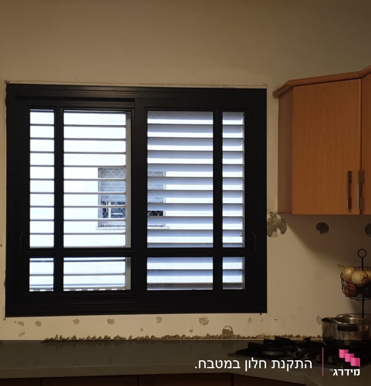 חלון אלומיניום שחור עם תריסים לבנים במטבח